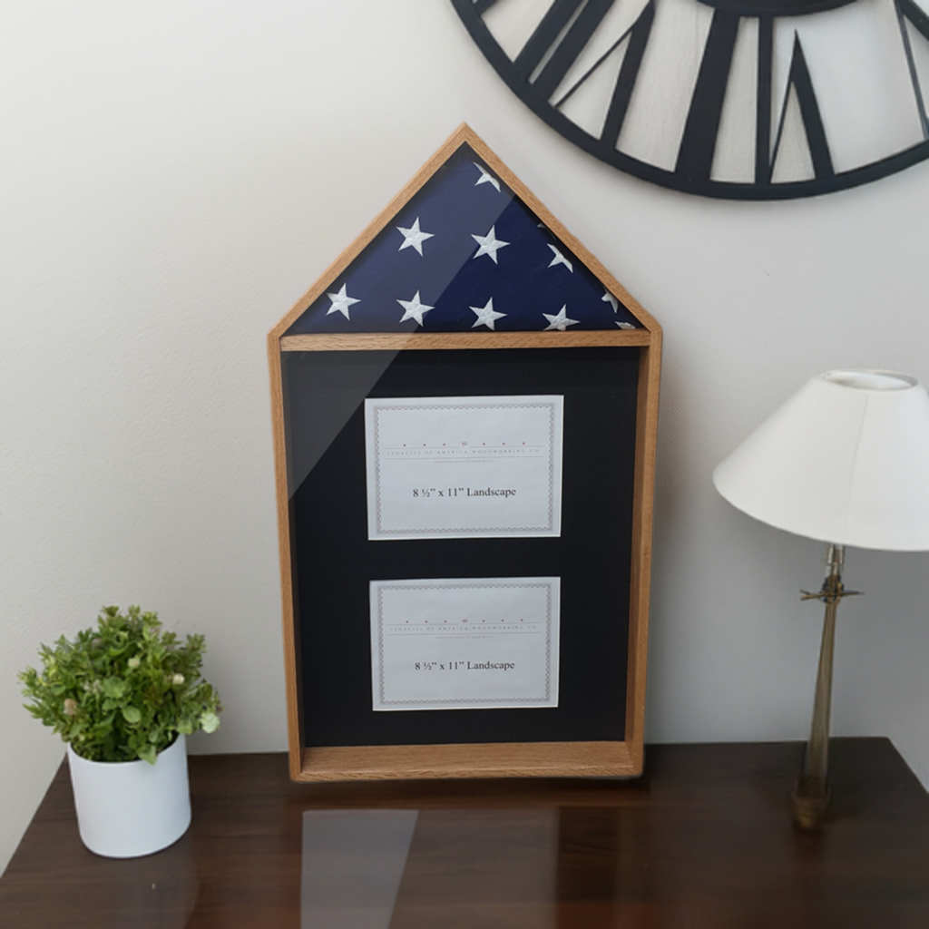Legacies of America Woodworking Co. Oak hardwood 4' x 6' Flag with 2 certificate displayed in the shadow box area. Made with real hardwood and real glass, handcrafted by U.S. Military Veterans in America. Shown on a table next to a lamp and a plant.