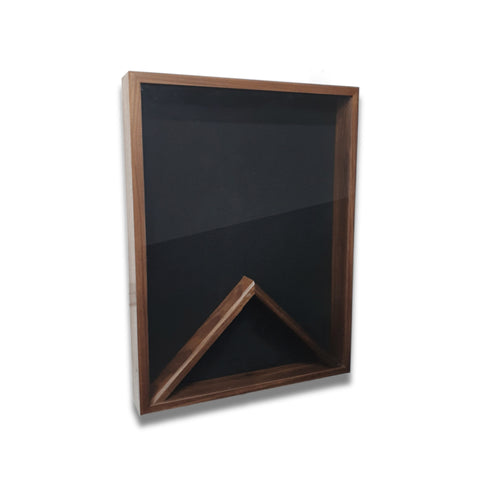 Walnut 18x24 vertical shadow box shown at a slight left angle with black felt backing and no flag displayed
