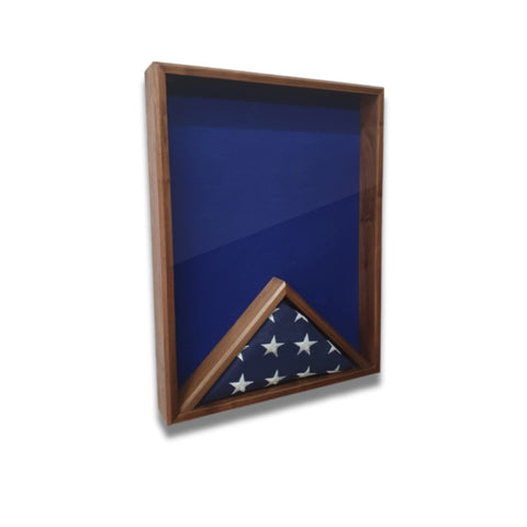 Walnut 18x24 vertical shadow box shown at a slight left angle with blue felt backing and a folded American flag inside
